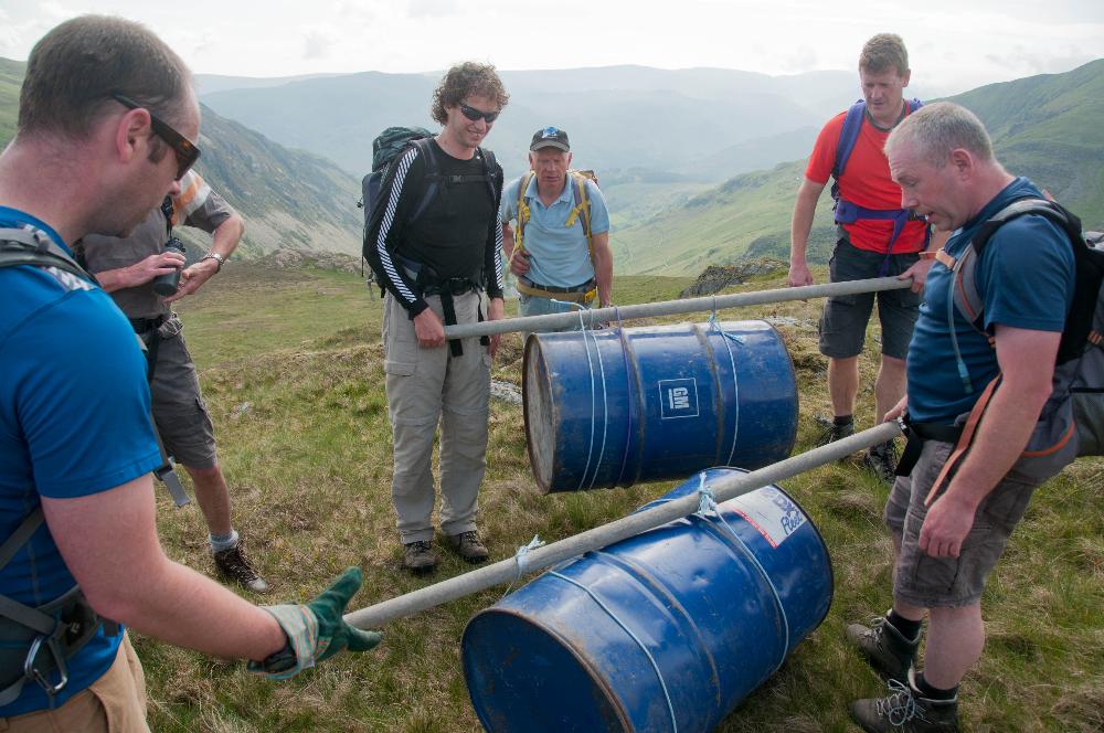 Carrying empty fuel drums up from the car park